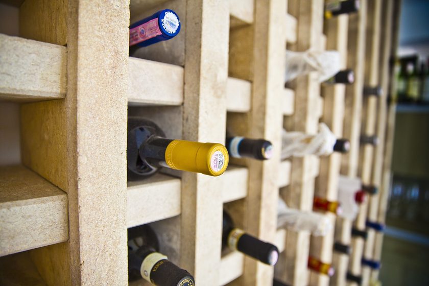 Bottles resting in the limestone cubbies of the wine rack